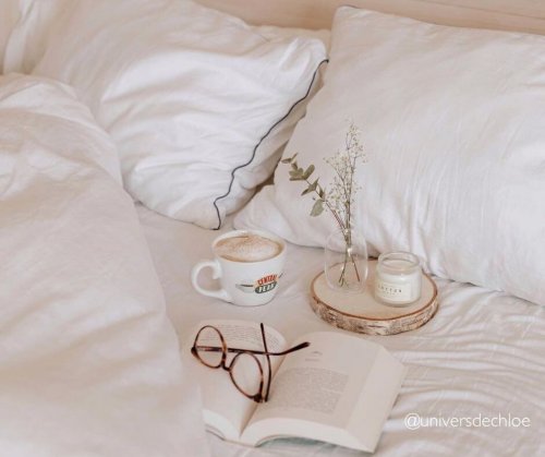 Livre et café posé sur un lit défait